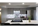 Modern kitchen with gray cabinets, stainless steel appliances, and breakfast bar at 4320 W Keim Dr, Glendale, AZ 85301