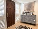 Elegant entryway featuring a statement wooden door and stylish console table at 6318 N 14Th St, Phoenix, AZ 85014