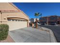 Tan house with a two-car garage and a palm tree in front, other houses visible at 7008 W Cesar St, Peoria, AZ 85345