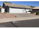 House exterior with a two-car garage and desert landscaping at 10840 E Keats Ave, Mesa, AZ 85209
