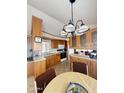 Bright kitchen with wood cabinets, an island, and a chandelier over the dining area at 1448 S Zuni --, Apache Junction, AZ 85119