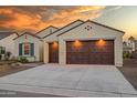 Two-car garage home with brown doors and drought-tolerant landscaping at 16541 W Edgemont Ave, Goodyear, AZ 85395