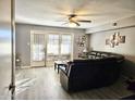 Living room with dark leather sofa, wood-look floors, and patio doors at 2121 W Union Hills Dr # 115, Phoenix, AZ 85027
