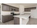 Modern kitchen with dark gray cabinets, white countertops, and stainless steel appliances at 24520 W Duane Ln, Wittmann, AZ 85361