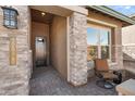 Inviting front entry with stone accents and a comfortable chair at 32978 N 131St Dr, Peoria, AZ 85383