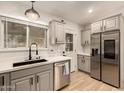 Modern kitchen with stainless steel appliances and a farmhouse sink at 5715 N 105Th Ln, Glendale, AZ 85307