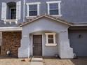 Front entrance of townhome, featuring a dark brown door and stonework at 9233 E Neville Ave # 1131, Mesa, AZ 85209