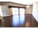 Open living room with wood floors, chandelier and sliding glass doors leading to the backyard at 10814 W Thunderbird Blvd, Sun City, AZ 85351