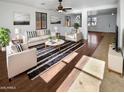 Bright living room featuring hardwood floors, comfortable seating, and large windows at 12037 W Via Del Sol Ct, Sun City, AZ 85373