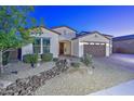 Two-story home with a three-car garage and nicely landscaped front yard at 16871 W Cielo Grande Ave, Surprise, AZ 85387