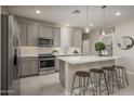 Modern kitchen with gray cabinets, white countertops and breakfast bar at 17058 W Seldon Ln, Waddell, AZ 85355