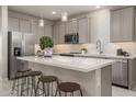 Modern kitchen with gray cabinets, white countertops and island with seating at 17058 W Seldon Ln, Waddell, AZ 85355