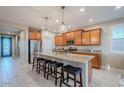 Island kitchen with wood cabinets, granite counters, and stainless steel appliances at 18055 W Muirwood Dr, Goodyear, AZ 85338