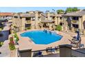 Community pool with surrounding patio and lounge chairs at 1880 E Morten Ave # 206, Phoenix, AZ 85020