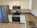 Stainless steel appliances and light-colored cabinets at 19002 N Toledo Ave, Maricopa, AZ 85138