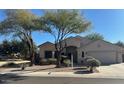 Tan colored house with a large front yard and driveway at 20457 N 80Th Dr, Peoria, AZ 85382