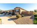 View of home's side elevation, showing stone accents and a gated side yard at 22643 E Stonecrest Dr, Queen Creek, AZ 85142