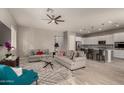 Open concept living room and kitchen with gray floors and white cabinets at 22643 E Stonecrest Dr, Queen Creek, AZ 85142