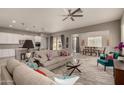 Open living area with modern sofas, a large TV, and a view of the kitchen at 22643 E Stonecrest Dr, Queen Creek, AZ 85142