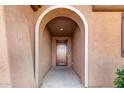 Covered entryway with arched entry and a dark brown front door at 25969 W Tina Ln, Buckeye, AZ 85396