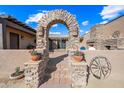 Stone arch entry to a private courtyard with a stone fireplace at 37209 N 12Th St, Phoenix, AZ 85086