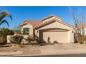 Tan two-story house with tile roof and two-car garage at 3818 N Lomond Cir, Mesa, AZ 85215