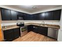 Modern kitchen with dark cabinets, granite countertops, and stainless steel appliances at 404 W 13Th St, Eloy, AZ 85131