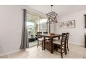 Dining area with wooden table and access to a patio at 40561 W Hillman Dr, Maricopa, AZ 85138