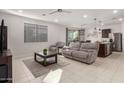 Bright, open living room with tile floors, neutral paint, and modern fixtures; a comfortable and inviting space at 40561 W Hillman Dr, Maricopa, AZ 85138