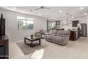 Spacious living room with gray couch and tile floor at 40561 W Hillman Dr, Maricopa, AZ 85138