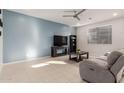 Comfortable living room with plush seating, tiled floors, a ceiling fan, and a calming blue accent wall at 40561 W Hillman Dr, Maricopa, AZ 85138