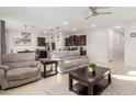 Open living room with kitchen view and gray couches at 40561 W Hillman Dr, Maricopa, AZ 85138