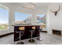 Interior home bar space with three stools, modern lighting, and views of mountains at 5655 N Camelback Canyon Dr, Phoenix, AZ 85018