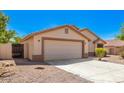 Tan house with a two-car garage and desert landscaping at 603 W Sierra Vista Dr, Apache Junction, AZ 85120