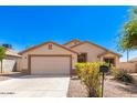 Tan house with a two-car garage and nicely landscaped yard at 603 W Sierra Vista Dr, Apache Junction, AZ 85120