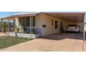 Single-wide manufactured home with carport and paved driveway at 630 S 93Rd Pl, Mesa, AZ 85208