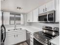 White kitchen with stainless steel appliances and double sink at 6454 E University Dr # 24, Mesa, AZ 85205