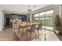 Bright dining area with modern light fixture, light wood floors, and large sliding doors to patio at 815 S 151St Ln, Goodyear, AZ 85338