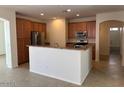 Open kitchen showcases wood cabinetry, stainless steel appliances, and a counter island for seating at 8498 W Maya Dr, Peoria, AZ 85383
