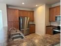 Kitchen with stainless steel appliances, wood cabinets, and stone countertops at 8498 W Maya Dr, Peoria, AZ 85383