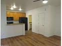 Living room with hardwood floors, kitchen island, and wood cabinets at 15818 N 25Th St # 116, Phoenix, AZ 85032