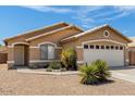 Tan one-story house with a two-car garage and desert landscaping at 15913 W Elm St, Surprise, AZ 85374