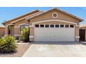 Tan one-story house with a two-car garage and desert landscaping at 15913 W Elm St, Surprise, AZ 85374