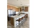 Spacious kitchen features stainless steel appliances, central island with barstool seating, and white subway tile backsplash at 32040 N Lisadre Ln, San Tan Valley, AZ 85144