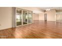 Living room with wood floors and sliding glass doors leading to a patio at 10161 W Pineaire Dr, Sun City, AZ 85351