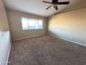 Spacious living room with carpeted floors and a ceiling fan at 13943 S Amado Blvd, Arizona City, AZ 85123