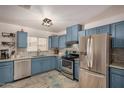 Modern kitchen with blue cabinets, stainless steel appliances, and granite countertops at 1510 E Ironwood Dr, Buckeye, AZ 85326