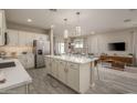 Modern kitchen with white cabinets, a large island, and stainless steel appliances at 17066 W Seldon Ln, Waddell, AZ 85355