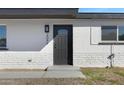 Modern home's exterior features a dark gray door and white brick at 2046 E Alder Cir, Mesa, AZ 85204