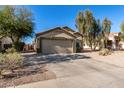 House exterior showcasing a two-car garage and mature trees at 2135 N St Pedro Ave, Casa Grande, AZ 85122